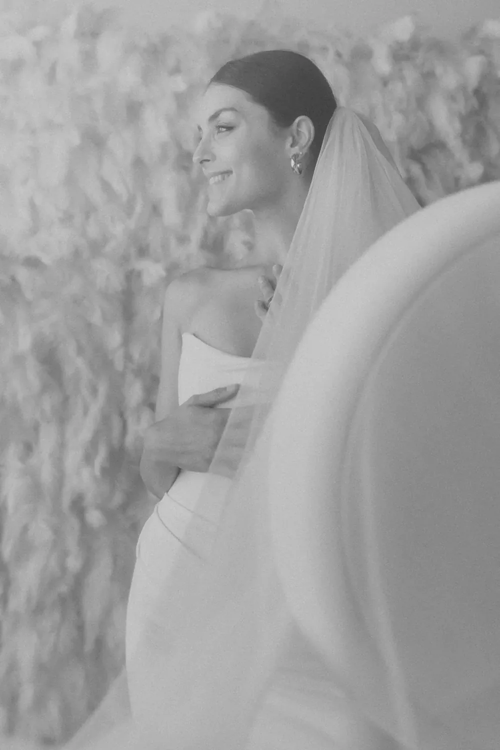 Black and white portrait of a guest against a white textured wall