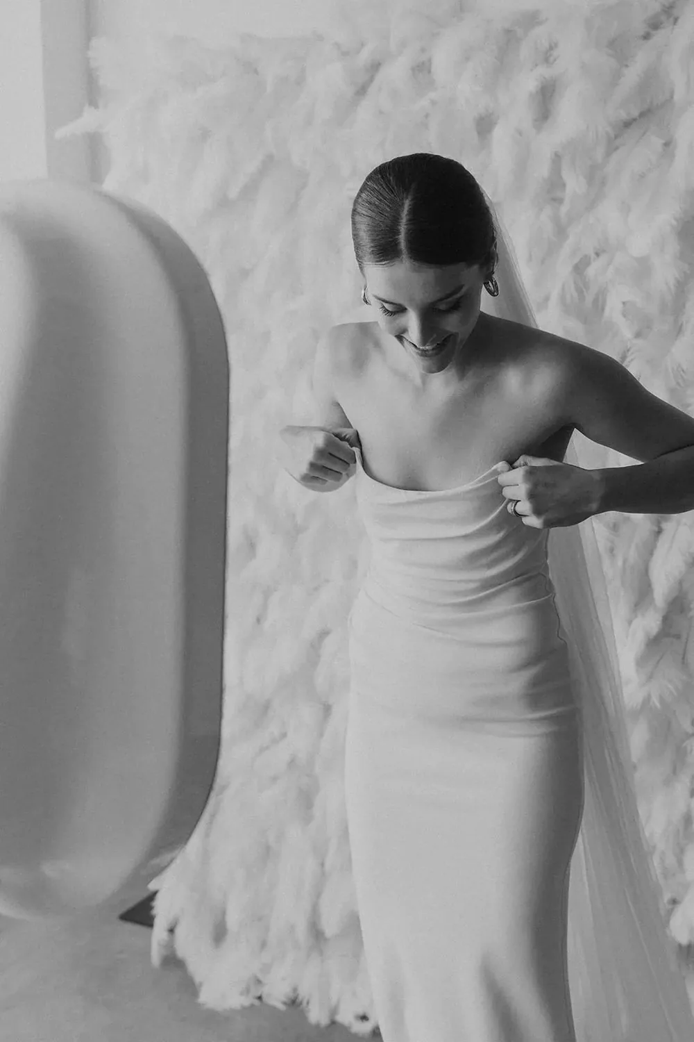 Guest posing against a soft white textured backdrop