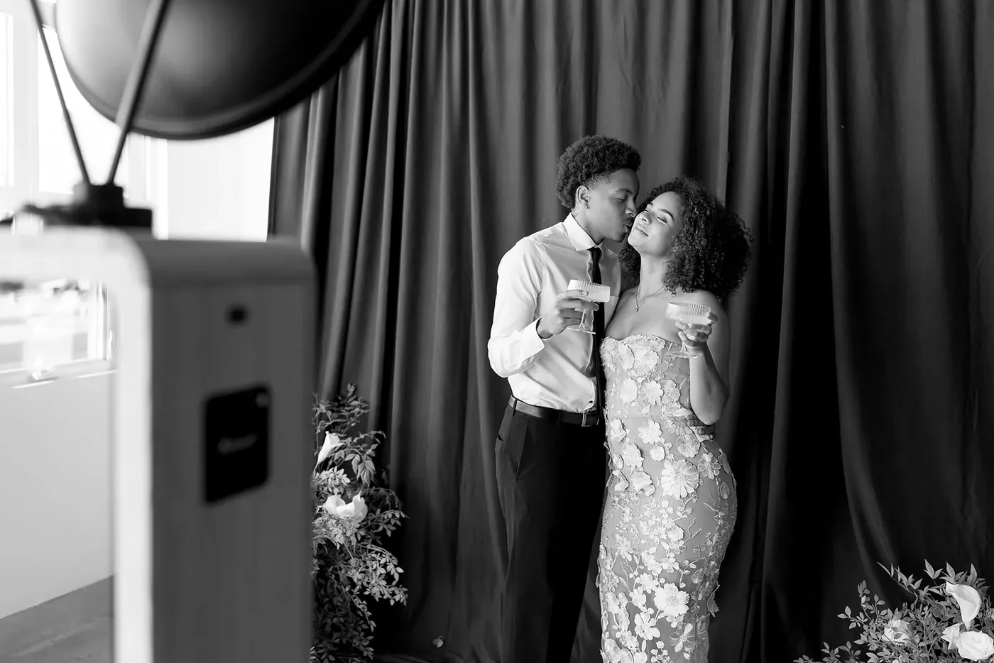 Black and white photograph of a couple in front of a draped backdrop