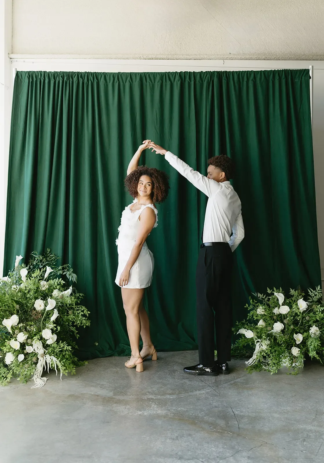 Couple dancing together in front of a draped backdrop