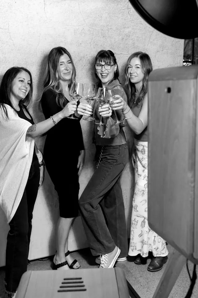 Black and white photograph of guests raising their glasses together