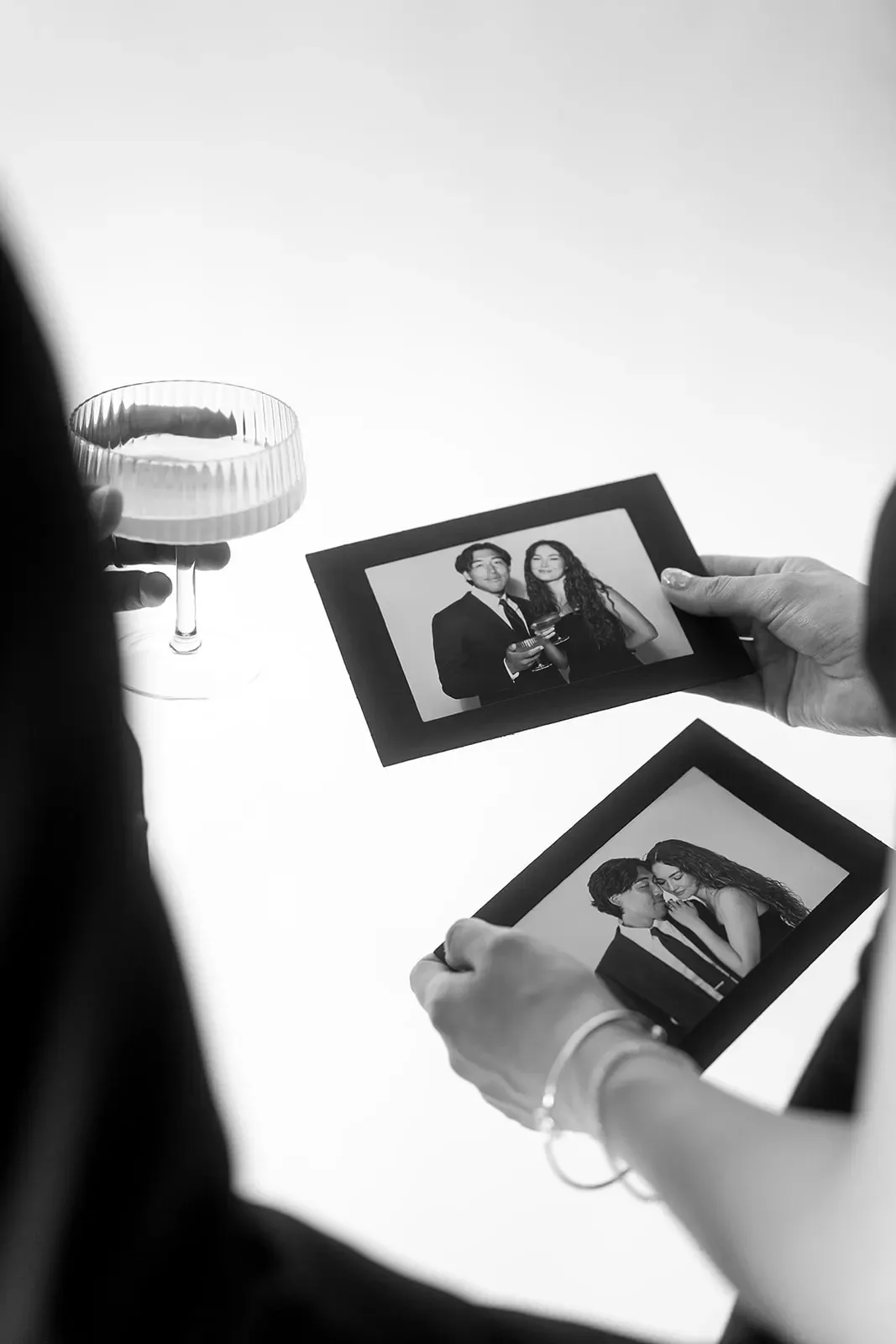 Two guests holding framed black and white prints fresh from the booth