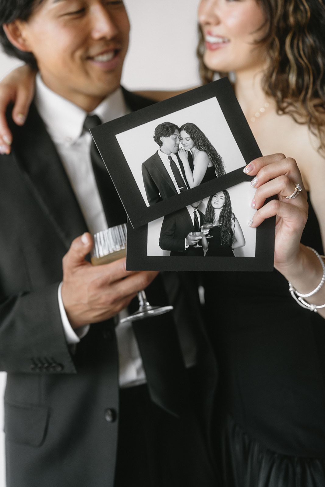 Couple holding two matted photo prints from a photo booth.